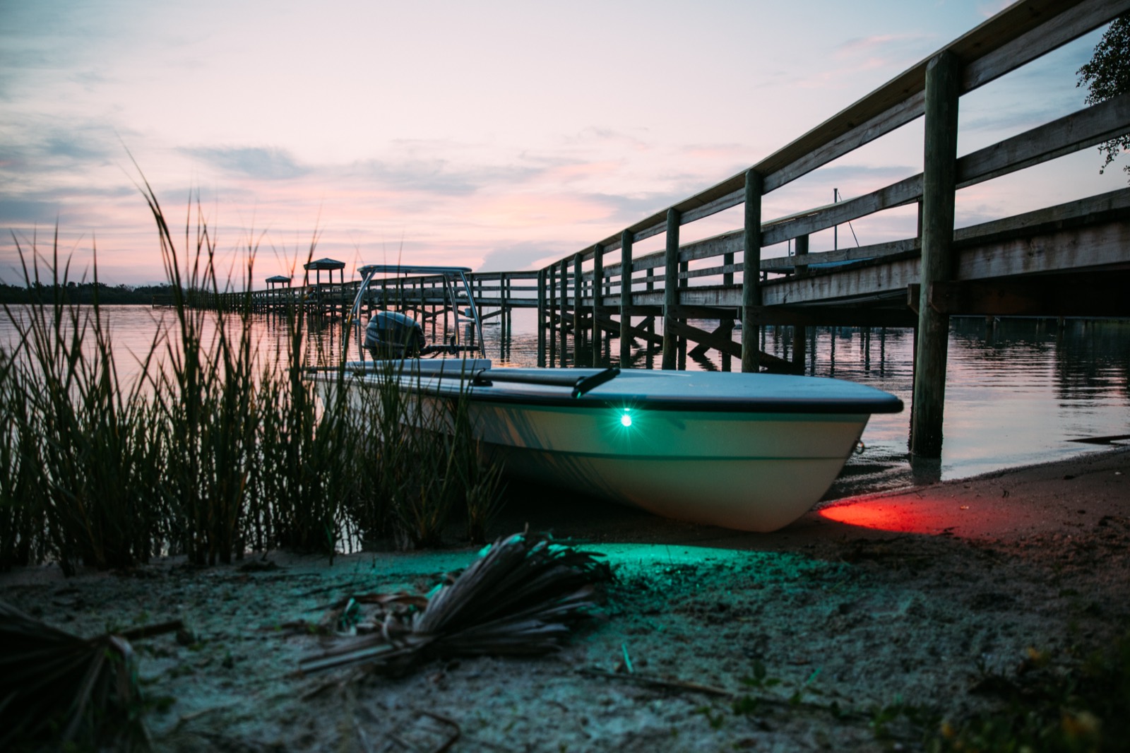 The Whipray pulled up on the sand at dusk beside a long wooden dock, running lights lit