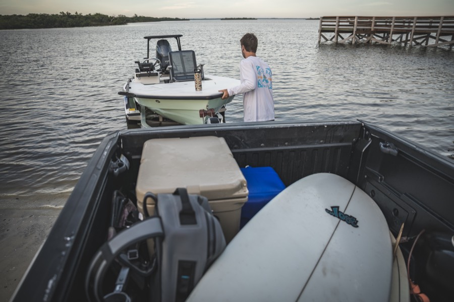 Launching the skiff at first light, gear and a surfboard in the truck bed
